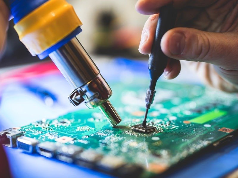 Hands soldering a component onto a PCB
