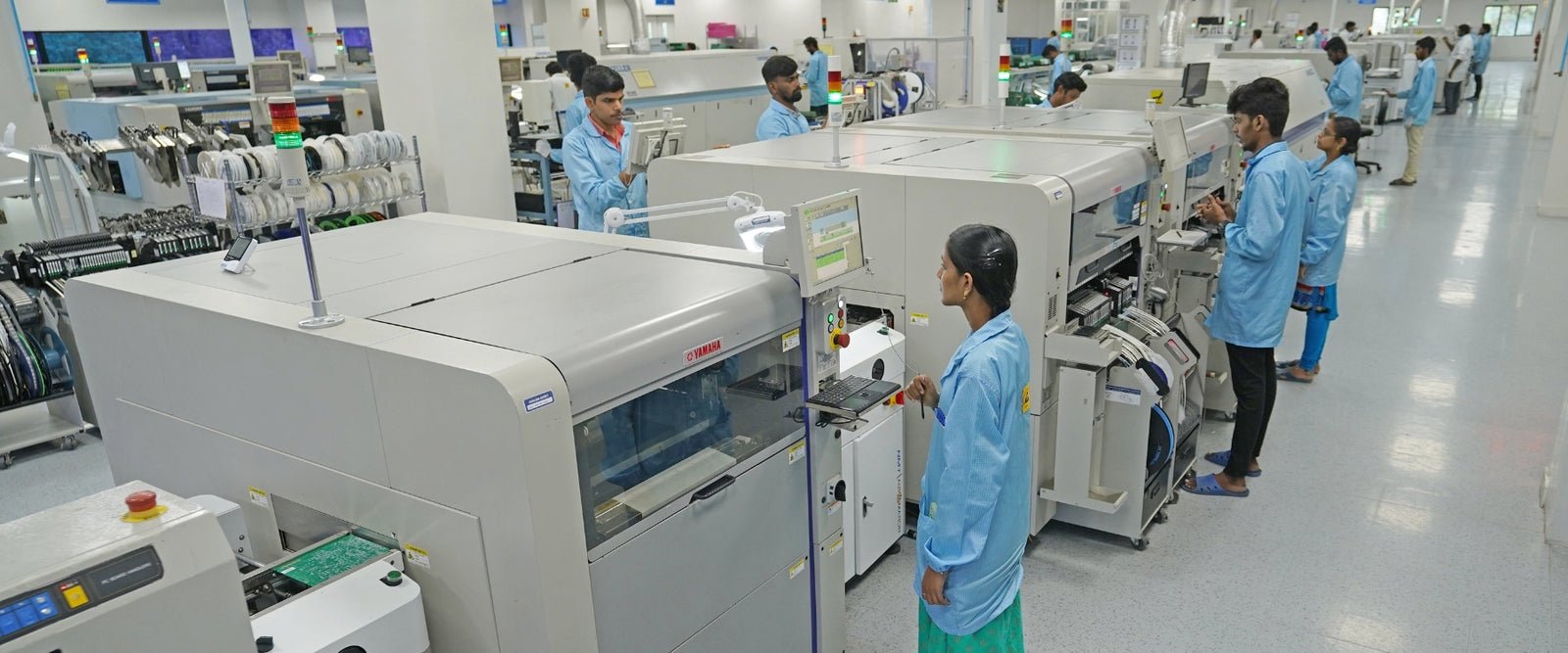SMT assembly line with engineers operating pick-and-place machines